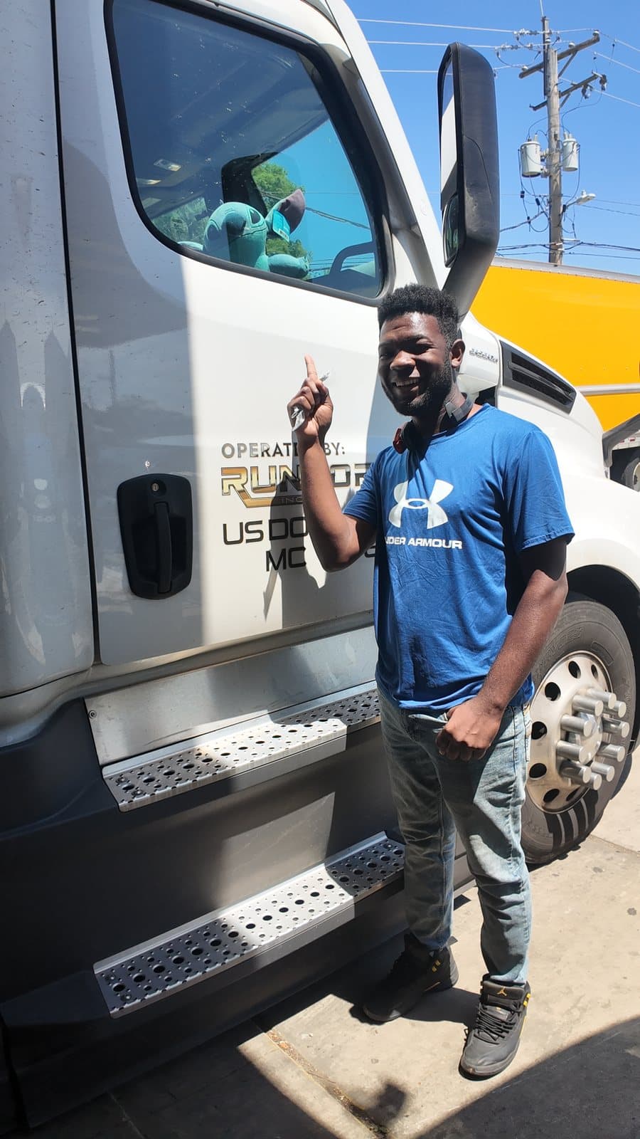 A smiling RUNFOREST driver by the door of his truck