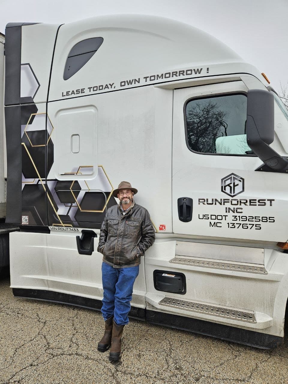 A RUNFOREST driver standing proudly beside his truck